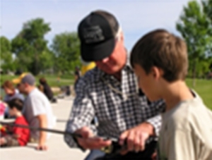 Older Gentleman teaching a younger man how to fish